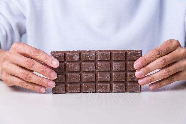 Mãos de mulher oferecendo um chocolatexA