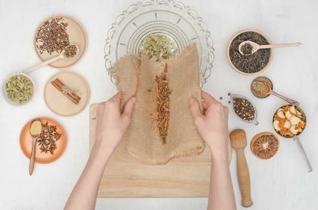 Mãos de mulher preparando chá indiano de masala com especiarias