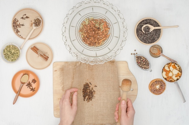 Mãos de mulher preparando chá indiano de masala com especiarias