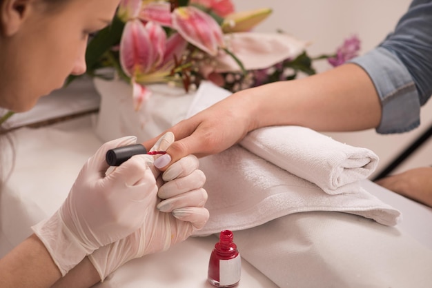 Mãos de mulher recebendo uma manicure no salão de beleza. Lixamento de unhas. Feche, foco seletivo.