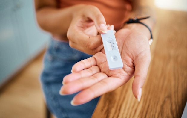 Mãos de mulher segurando um teste covid para saúde de segurança e medicamentos com resultado negativo Close de um kit de teste rápido de antígeno de coronavírus para um exame de diagnóstico médico com um dispositivo pcr em casa