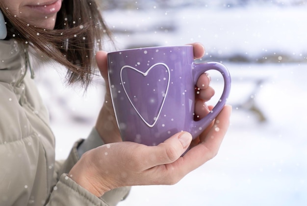 Mãos de mulher segurando uma xícara quente de chá de café