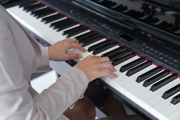 Mãos de mulher tocando piano