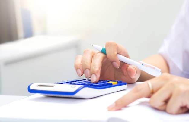 Mãos de mulher trabalhando na calculadora