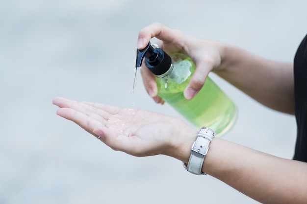 Mãos de mulher usando dispensador de gel desinfetante para as mãos, contra novos coronavírus ou Corona Virus Disease (Covid-19) em público Indoor.