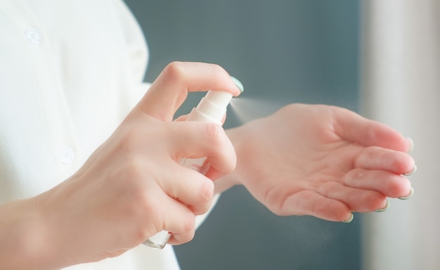 Mãos de mulher usando spray anti-séptico. coronavir pandêmico covid-19. proteção contra bactérias e vírus.