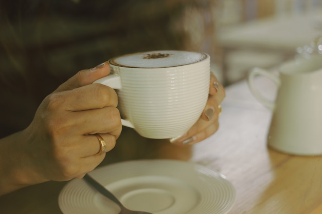 Mãos de mulheres jovens e café mocha