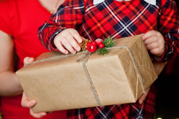 Mãos de pai e filho segurando uma caixa de presente de Natal. Decoração de Natal. Família feliz na época do Natal. Feriados de ano novo e inverno