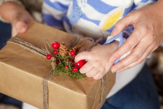 Mãos de pai e filho segurando uma caixa de presente de Natal. Feliz Ano Novo