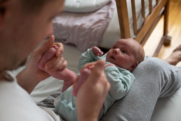 Mãos de pai segurando os pés do bebê verificando o reflexo de um recém-nascido