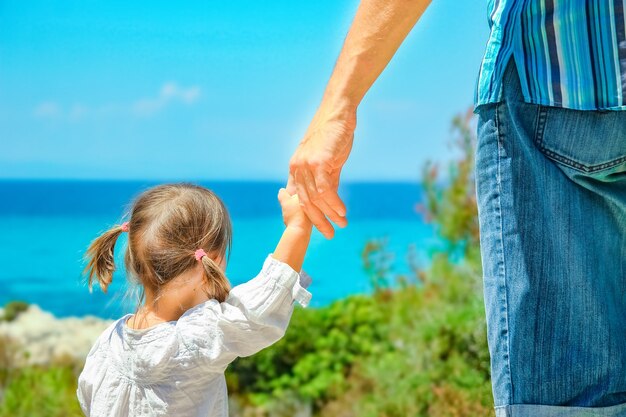 Mãos de pais e filhos felizes à beira-mar