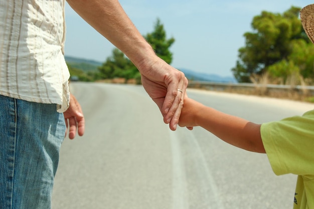 Mãos de pais e filhos felizes no mar em viagens de fundo na grécia