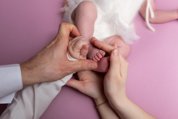 mãos de pais e filhos. pernas de um recém-nascido nas mãos da mãe e do pai. as pernas do bebê nas mãos.