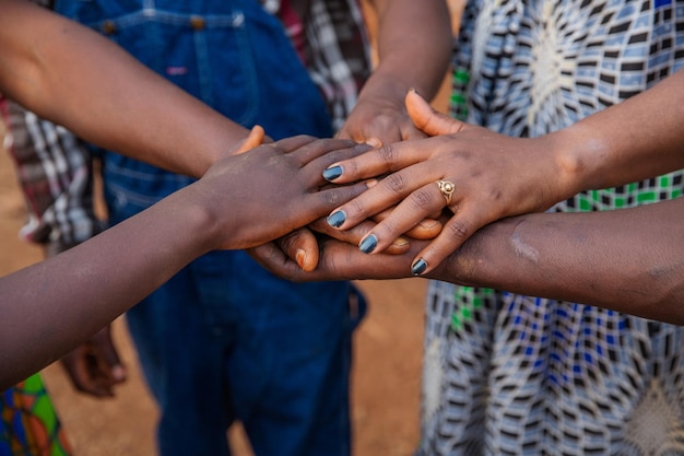 Mãos de pessoas africanas umas sobre as outras conceito de unidade