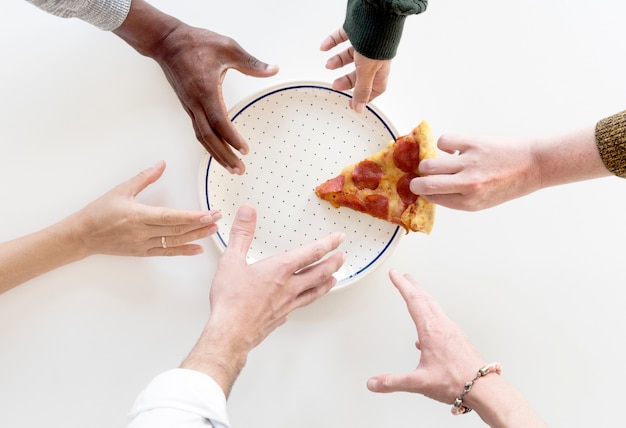 Mãos de pessoas agarrando a última fatia de Pizza