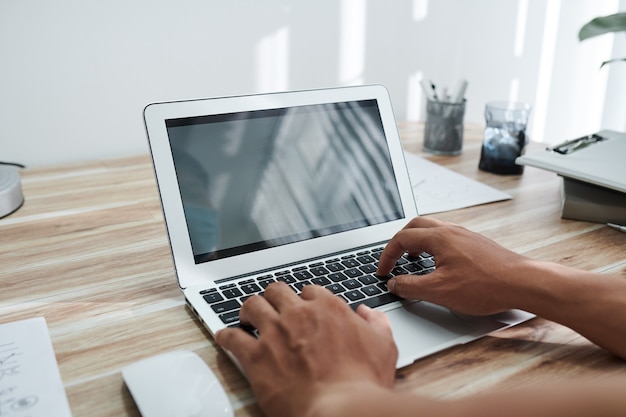 Mãos de programador codificando em um laptop em casa ou testando um novo programa