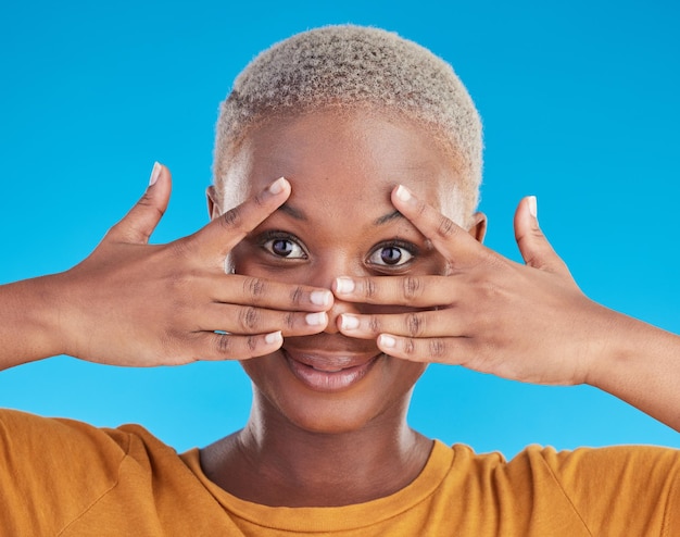 Mãos de rosto e cuidados com a pele de mulher negra para beleza em estúdio isolado em um fundo azul Retrato natural e modelo africano com cosméticos em tratamento facial para estética e saúde de bem-estar
