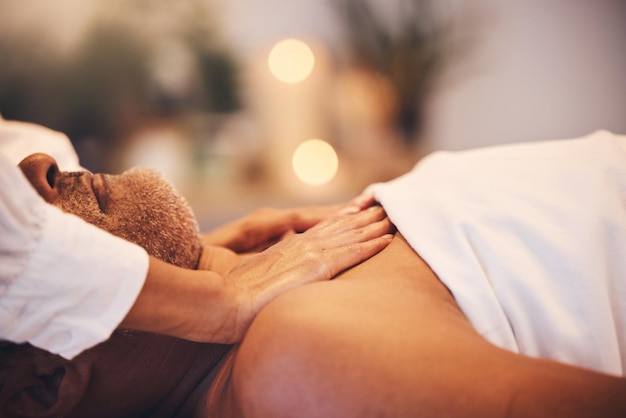 Mãos de spa e terapeuta de massagem com cliente homem em zen de luxo ou sala calma com bem-estar de fisioterapia e cura de férias Serviço de saúde Bokeh e trabalhador de beleza dando um tratamento corporal