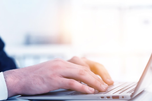 Mãos de um empresário pressionando o teclado. Empresário do local de trabalho