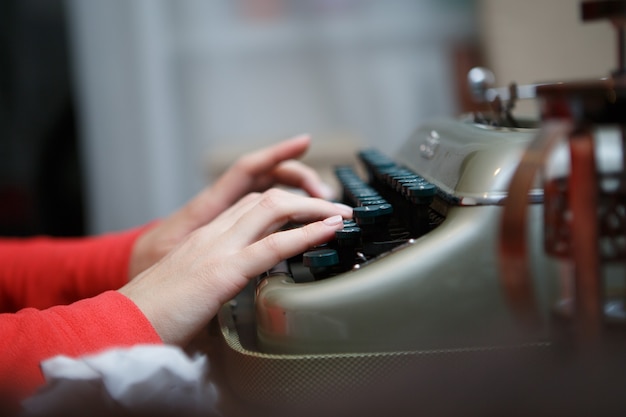 Mãos de um homem digitando na máquina de escrever