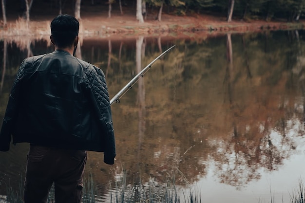 Foto mãos de um homem em um plano urp seguram uma vara de pescar