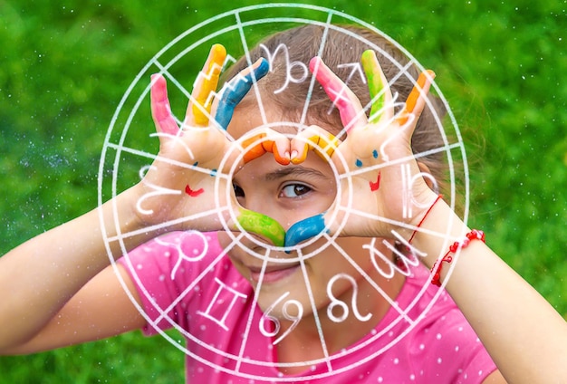 Mãos de uma criança com um sorriso desenhado signo do zodíaco Foco seletivo