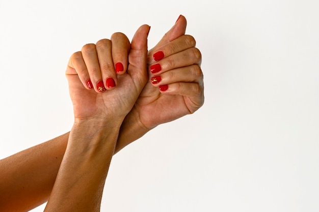 Mãos de uma jovem mostrando fundo branco de unhas pintadas