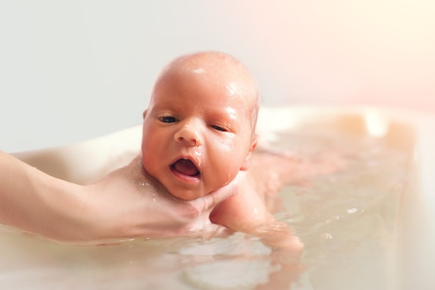 Foto mãos de uma mãe desconhecida cuidadosa segurando um menino