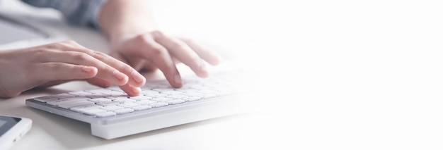 Mãos digitando no teclado do computador na mesa do escritório