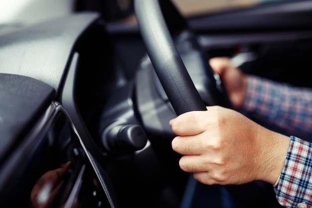 Mãos dirigindo um carro na rodovia