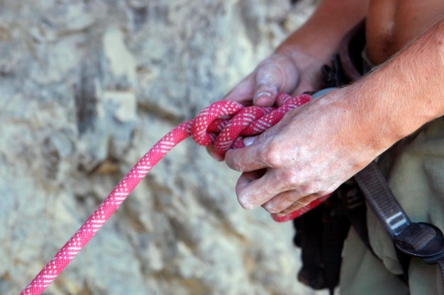 Foto mãos do alpinista fecham elementos de escalada de montanha