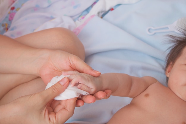 Mãos do bebê dormindo nas mãos da mãe