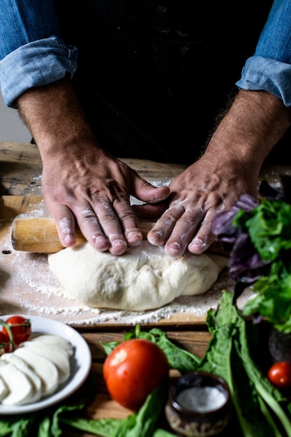 Foto mãos do chef italiano chef cozinhando massa homem mãos cozinhando massa de pizza para pizza