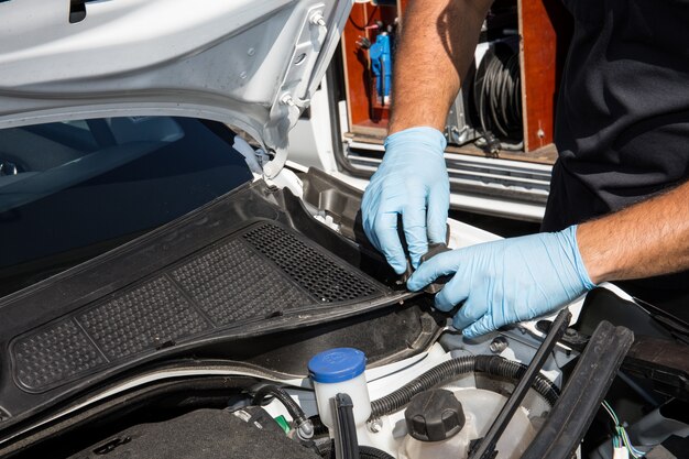 Mãos do mecânico de automóveis no serviço de reparo de automóveis.