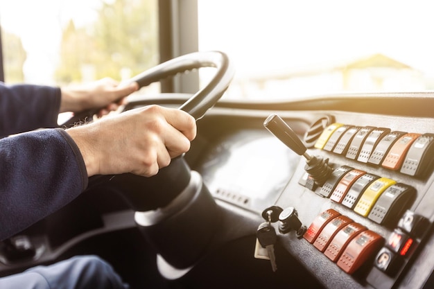 Mãos do motorista em um ônibus moderno de acordo com o detalhe de viagem do volante do motorista do ônibus