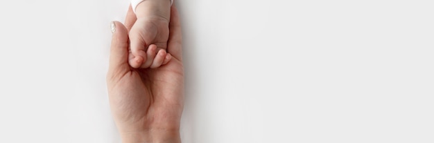 Mãos dos pais segurando os dedos do bebê recém-nascido, feche a mão da mãe segurando seu bebê recém-nascido