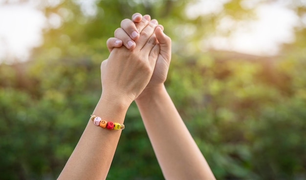 Mãos e corações juntos Close de um casal apaixonado de mãos dadas usando uma pulseira do pulso LOVE