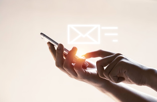 Mãos e ícone de carta virtual com telefone celular para enviar e-mail, conceito de tecnologia.