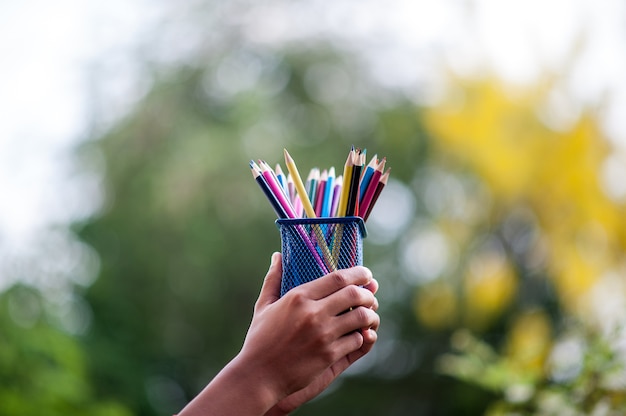 Mãos e lápis em muitas cores