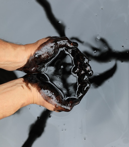 Foto mãos em petróleo preto bruto