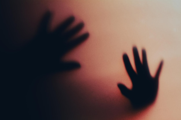 Mãos em silhueta mostrando sombras artísticas contra um gradiente de cor gradual