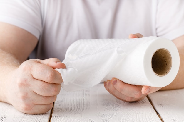 Mãos está segurando o rolo de papel toalha de cozinha