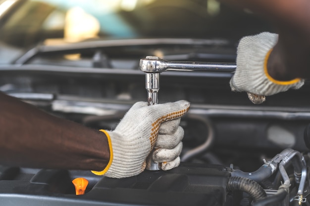 Mãos Expertise mecânico de automóveis em serviço de reparo de automóveis. Manutenção do carro e conceito de garagem de serviço automático.