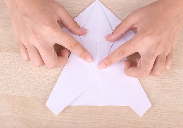 Mãos fazendo figura de origami de perto