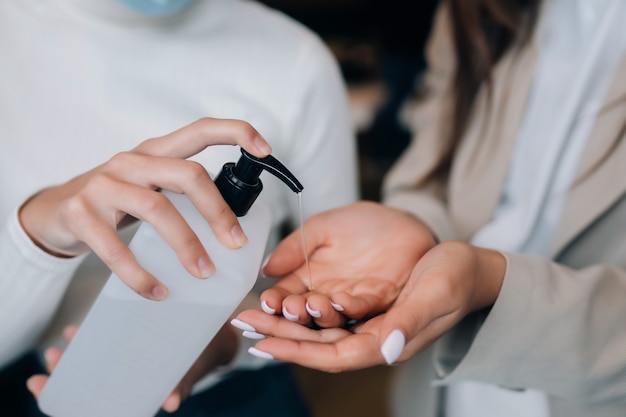 Mãos femininas aplicando sabonete líquido antibacteriano close-up