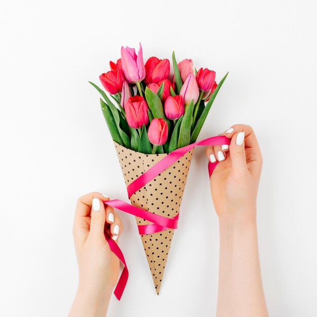 Mãos femininas com buquê de tulipas. Lindas flores rosa primavera.