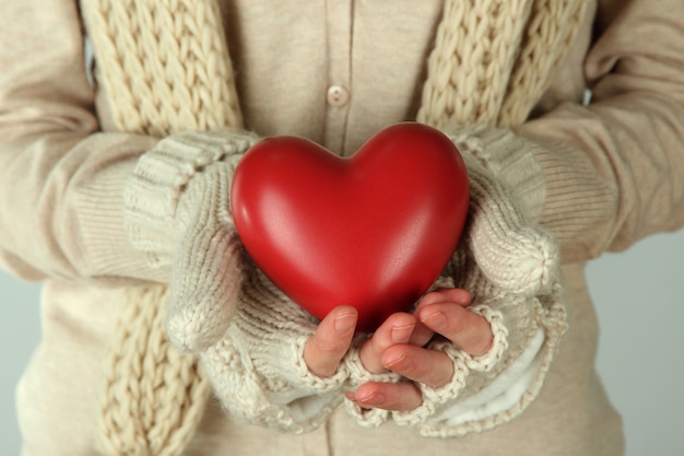 Mãos femininas com coração vermelho, close-up