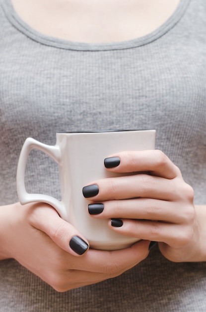 Mãos femininas com design preto unha fosca.