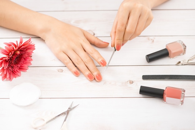 Mãos femininas com ferramentas para manicure. Cuidado das unhas.