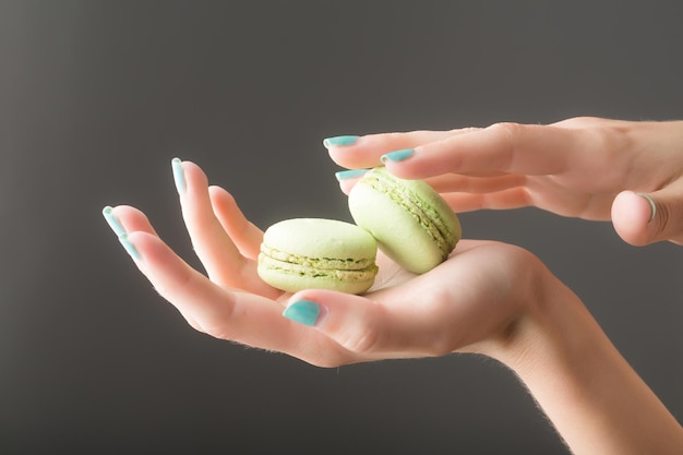 Mãos femininas com macaron